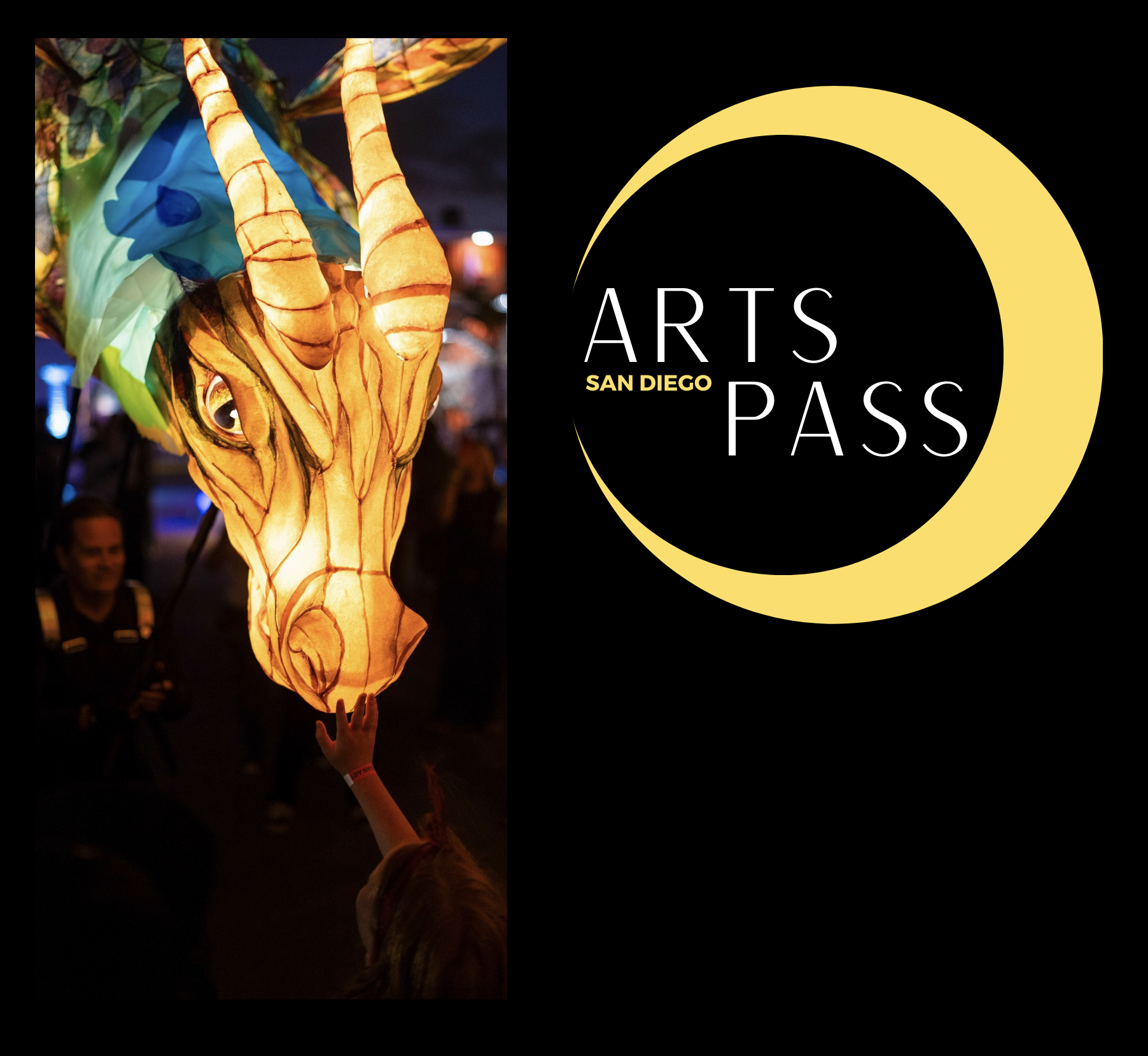 child reaching up to touch a lit-up paper dragon art piece with the San Diego Arts Pass logo next to it.